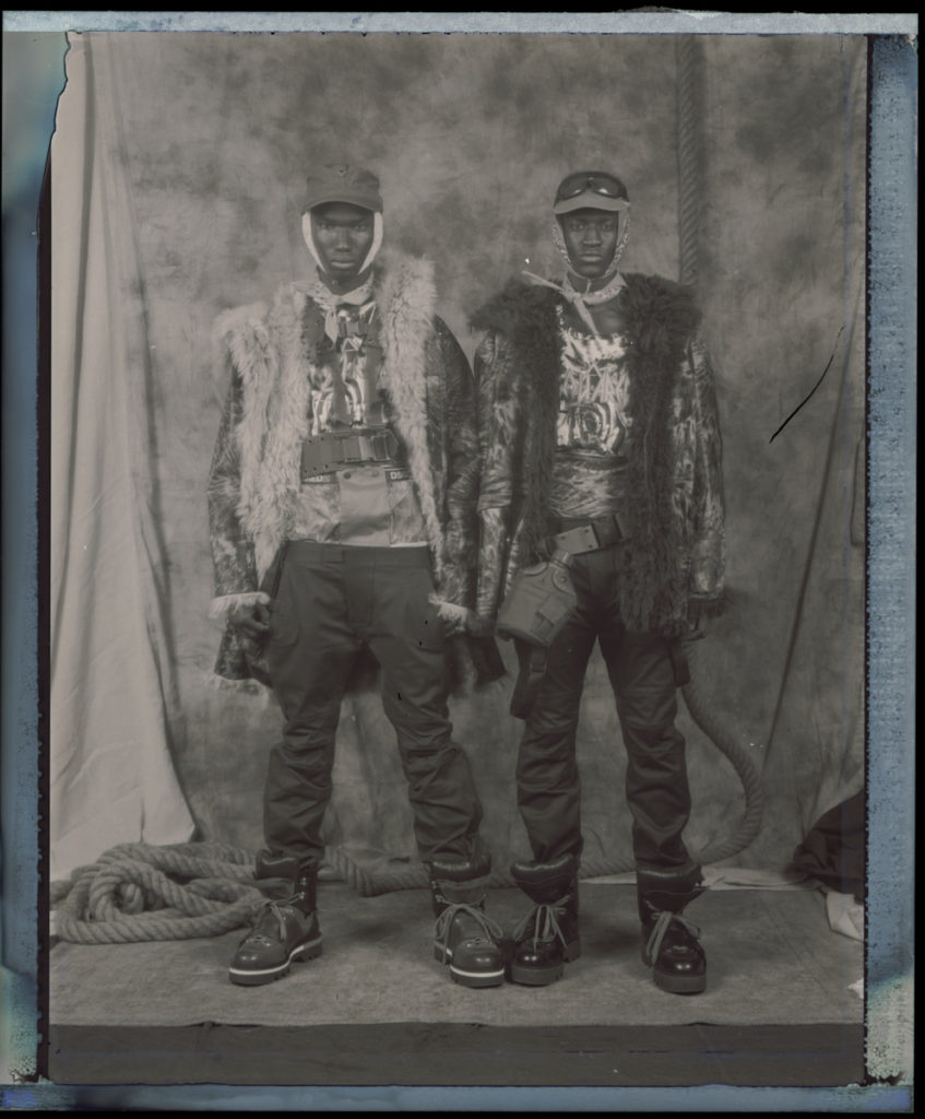 FROM LEFT: MUSA WEARS hat FRONT GENERAL. coat, top, pants, boots DSQUARED2. vest CHURCH ST SURPLUS. bandanas stylist's own. IBBY WEARS hat FRONT GENERAL. coat, top, pants, boots DSQUARED2. bandanas and belt stylist's own.